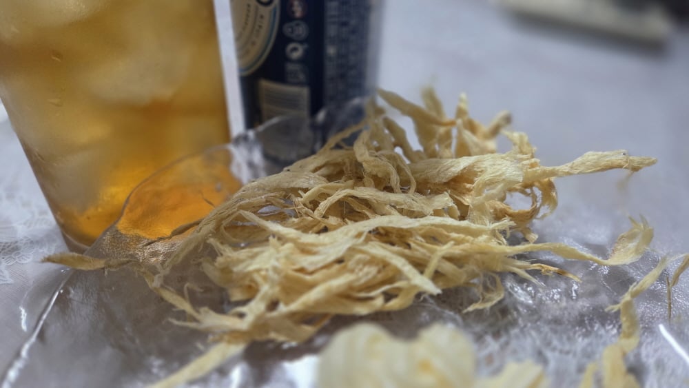 맥주와 함께 접시에 담아낸 바삭하게 데운 황태채